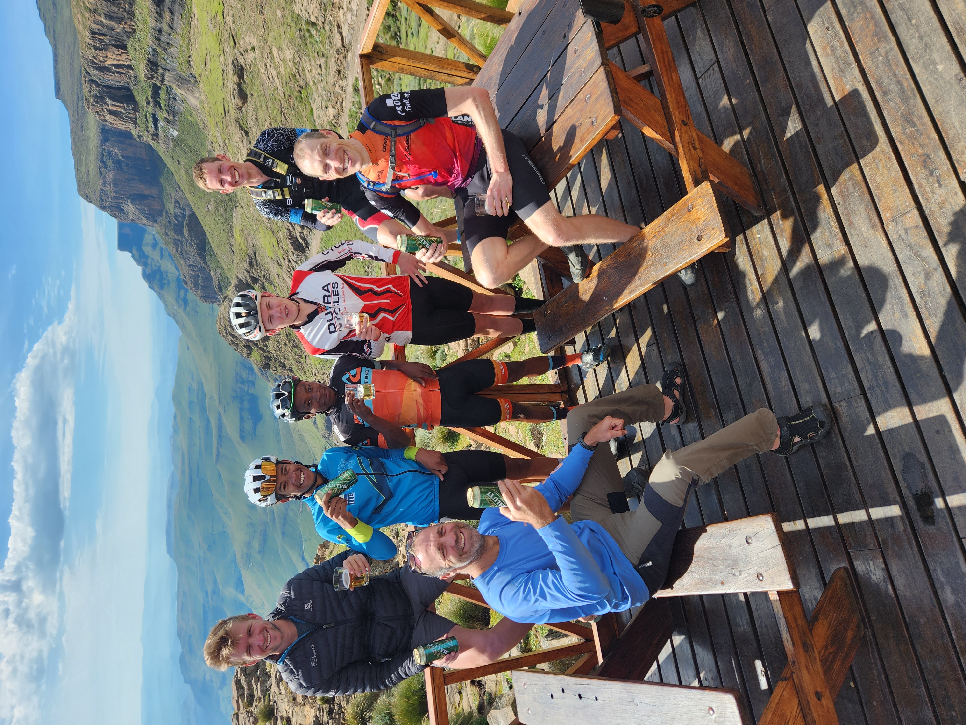 Riders celebrating with a view over the Lesotho highlands on a supported cycling adventure